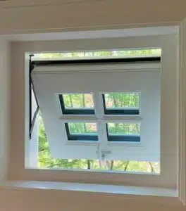 Tilted security window with four glass panes and a locking mechanism, surrounded by a white frame, designed by Shield Security Doors.