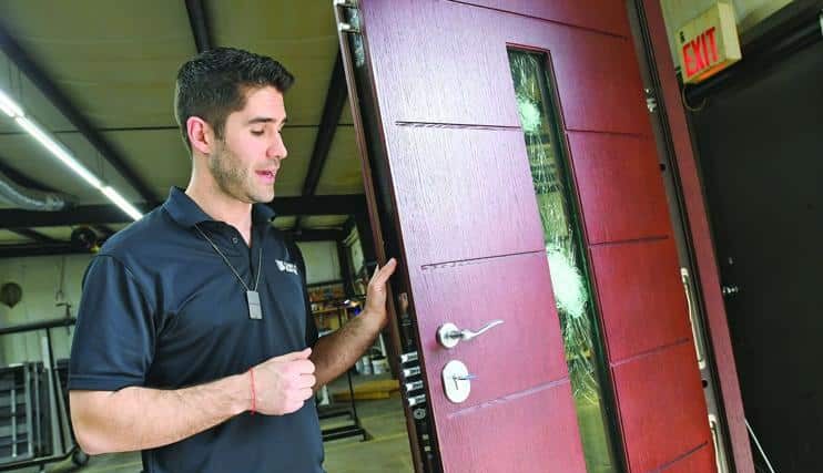 Samuel Fish, owner of Shield Security Doors, shows how one of the security doors made at his High Point company is designed with reinforced glass to stop an AK-47